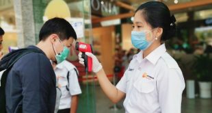 Trabajadores toman la temperatura de los clientes para descartar el coronavirus en un centro comercial de Yangon, Myanmar.