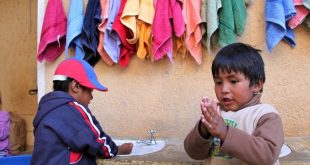 Dos niños en Bolivia se lavan las manos en una estación apoyada por UNICEF.